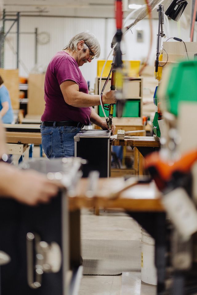 Person working on a task in a factory setting with machinery and equipment around.