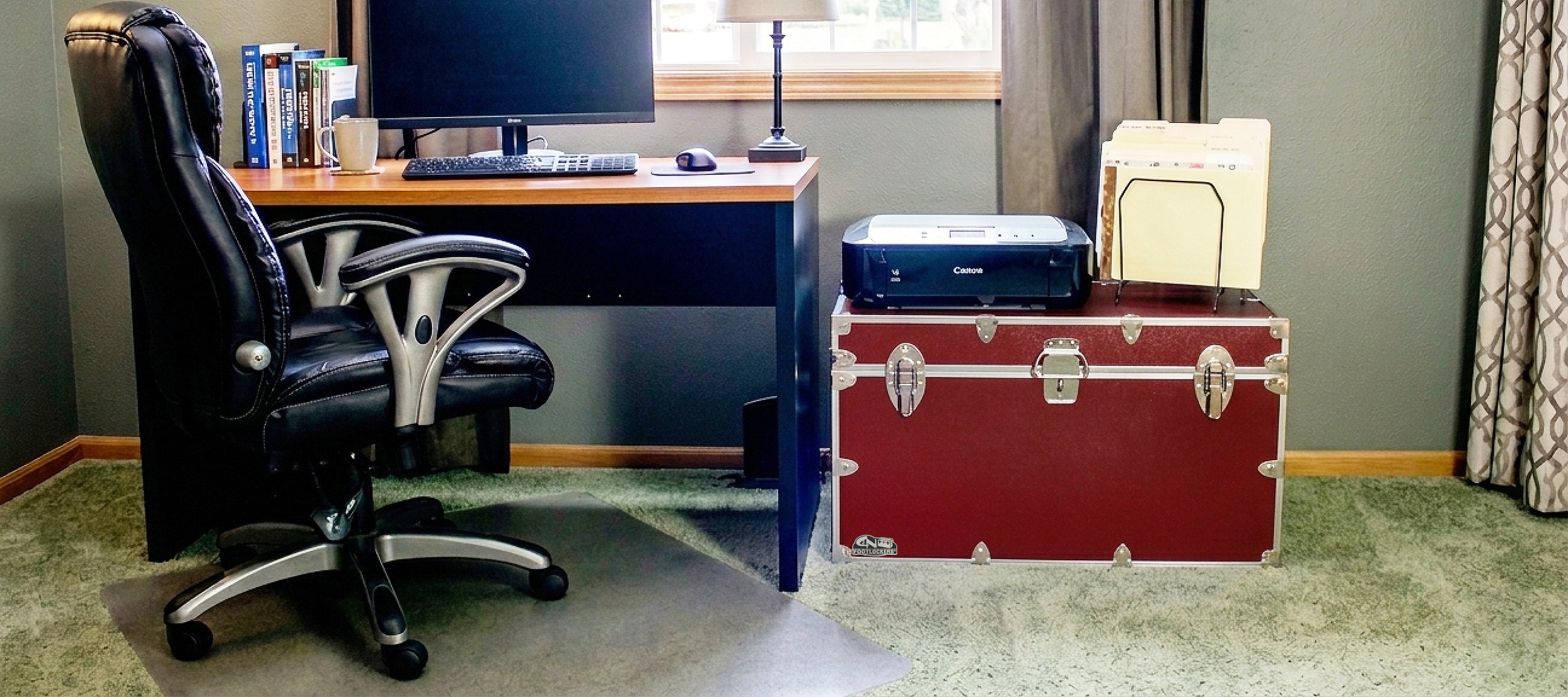 Home office with a desk, chair, and open trunk revealing office supplies.